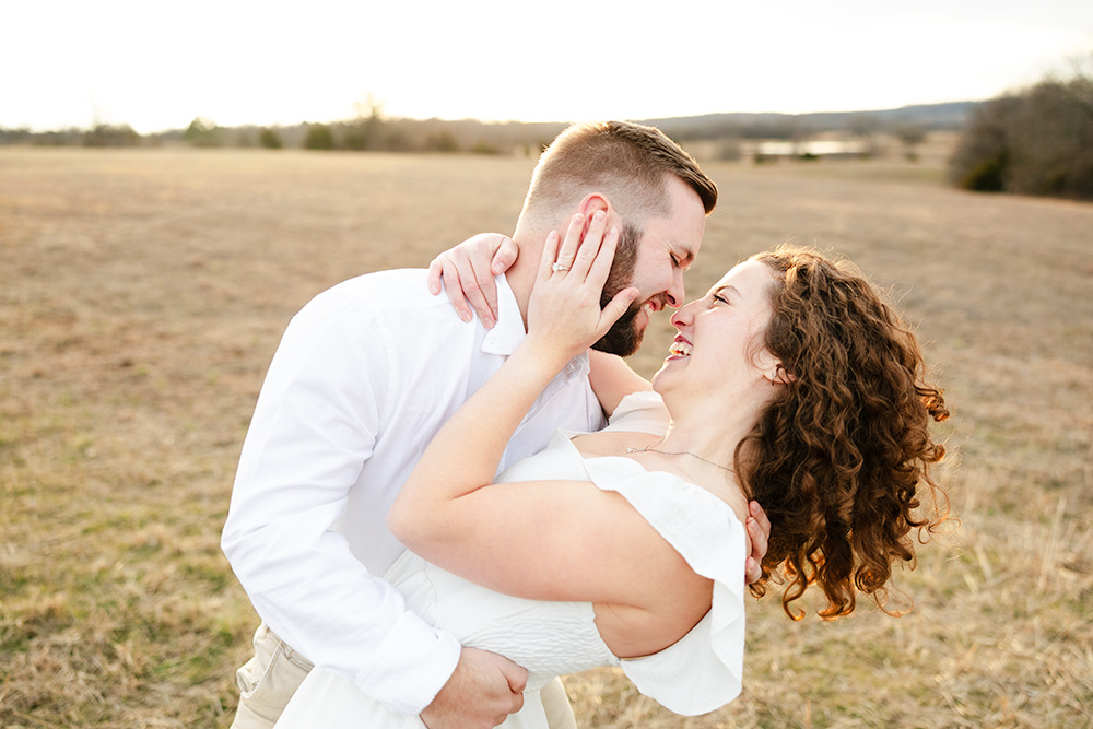 Couple dip kissing in a field in Oklahoma during their engagement session